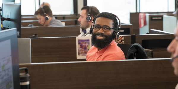 man with headset smiling at camera