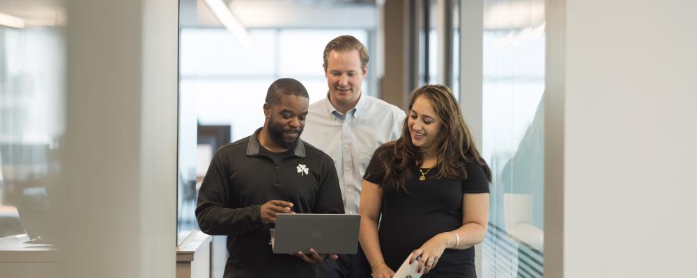 Three employees walking and talking